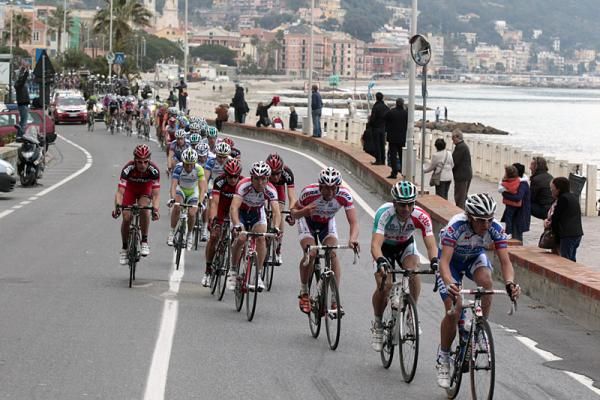 The lead group flies along the Ligurian Sea coast.