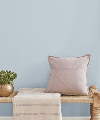 Light blue wall with pink pillow