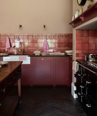 shaker kitchens, red and taupe kitchen with tiled backsplash, brass hanging rail, shelf, vintage table