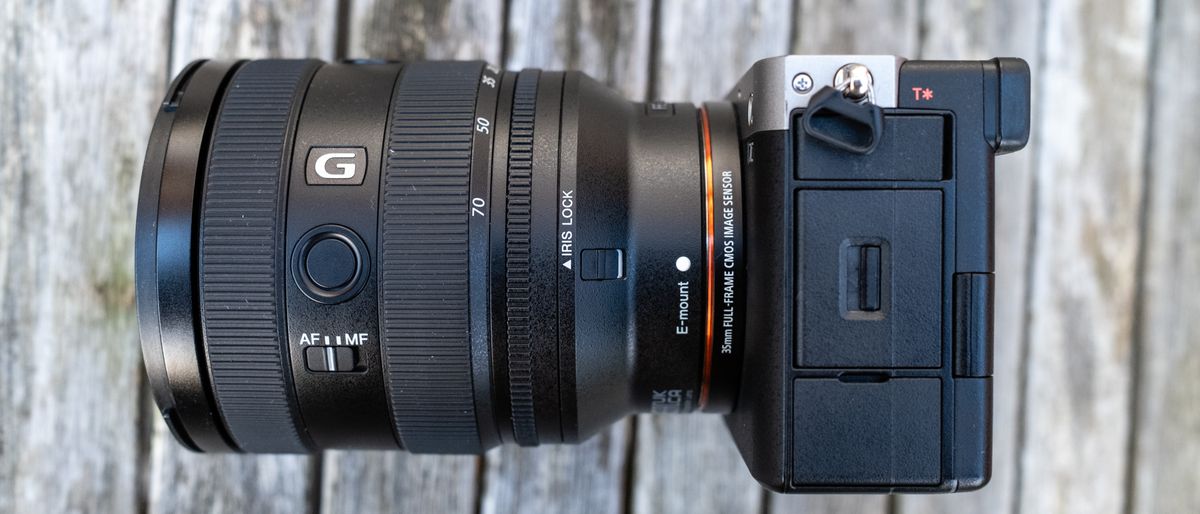 Sony FE 20-70mm F4 G attached to Sony A7C on wooden table close up