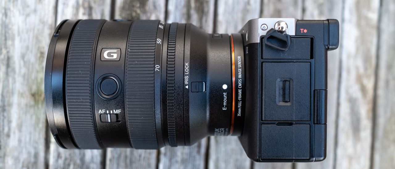 Sony FE 20-70mm F4 G attached to Sony A7C on wooden table close up