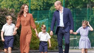 Prince George, Prince Louis and Princess Charlotte, all wearing school uniforms, walk with Prince William and Kate to attend a settling-in afternoon at Lambrook School in 2022