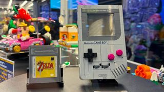 Lego Game Boy sitting on black table next to Zelda: Links Awakening cartridge.