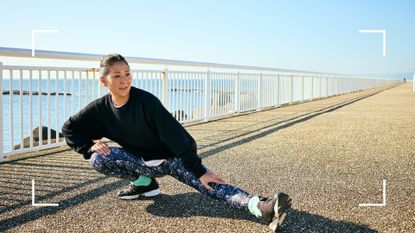 Woman stretching along beach promenade in workout clothes, after learning how to lower fitness age 