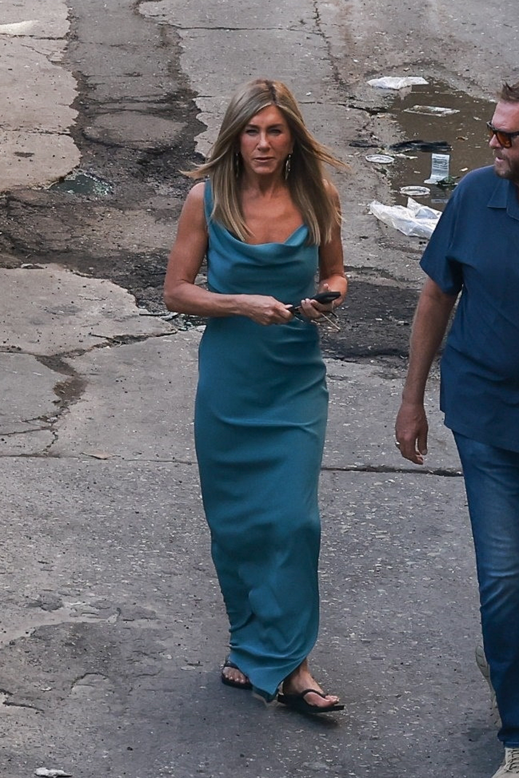Jennifer Aniston wears a maxi dress with black flip flops.