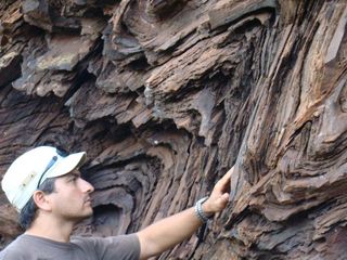 Ernesto Pecoits looks at the layers of rock in Uruguay where the tiny tracks of the earliest multicellular animal were discovered.