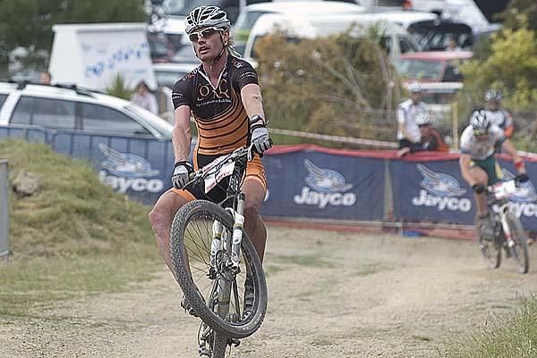 Daniel McConnell pulls a wheelie on the line to win the gold medal in the elite men's short track.
