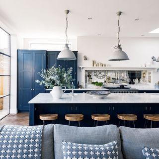 white kitchen with sofa and breakfast bar