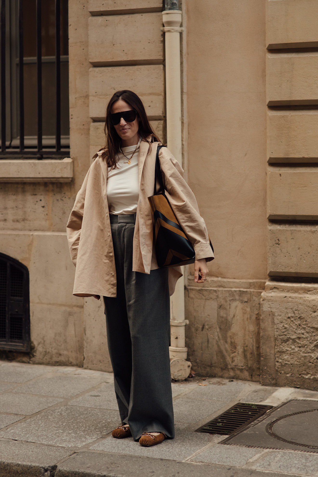 woman wearing jacket, white t-shirt, pants, and ballet flats