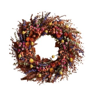 A fall wreath made from pink, blue, yellow and brown flowers, branches, and leaves