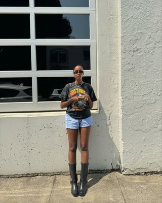 French woman wearing boxer shorts, vintage t shirt, and tall black boots