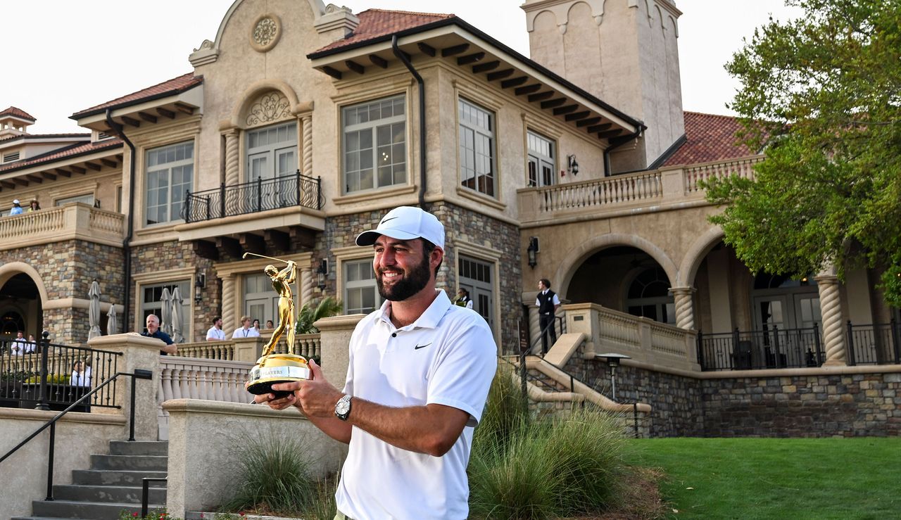 Scottie Scheffler holds The Players Championship trophy