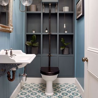 blue downstairs toilet with tongue and groove, built-in shelving and patterned tiles