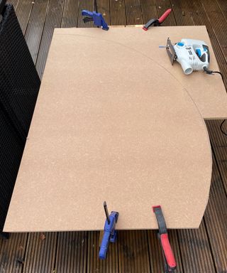 MDF sheet clamped down whilst being cut with jigsaw