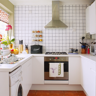u shaped kitchen with white tiles on wall and white cabinet