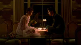 Sam and Jake Ryan sitting on her dining table with a cake between them in Sixteen Cnadles