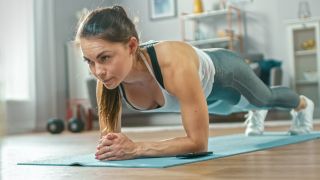Woman doing plank exercise on mat