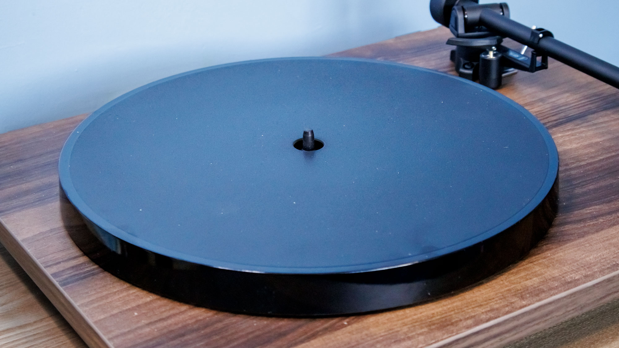 A closeup of the black platter of the Rega Planar 1 Plus turntable
