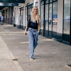 woman wearing jeans and sandals and a black tank top in nyc street style