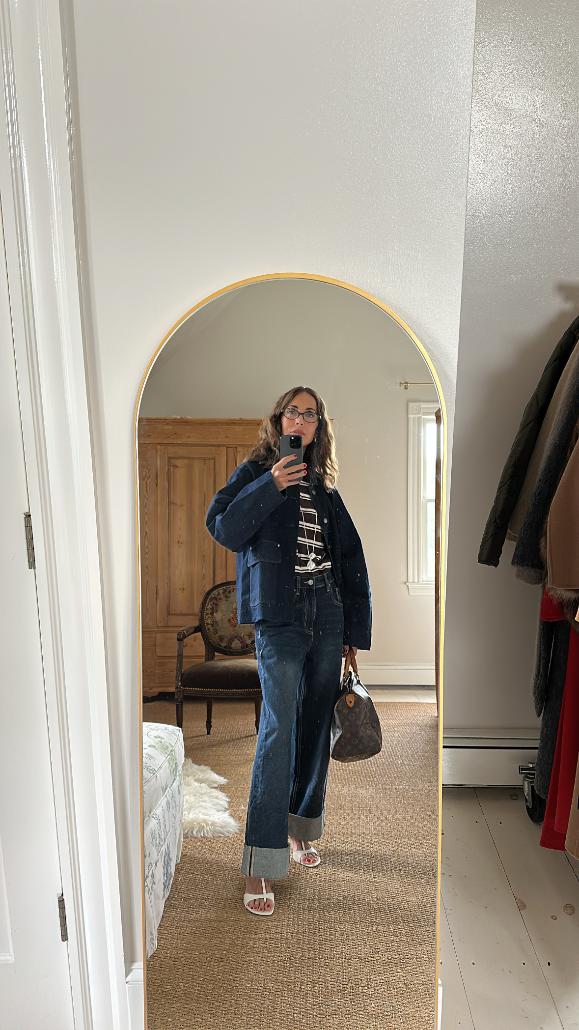 Larissa Mills wearing blue cuffed jeans, a striped tee, and a blue jacket