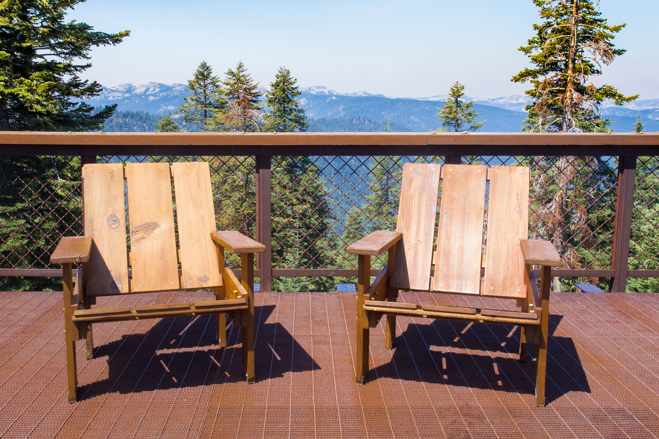Two wood chairs on outdoor sunny deck with California mountains in the background