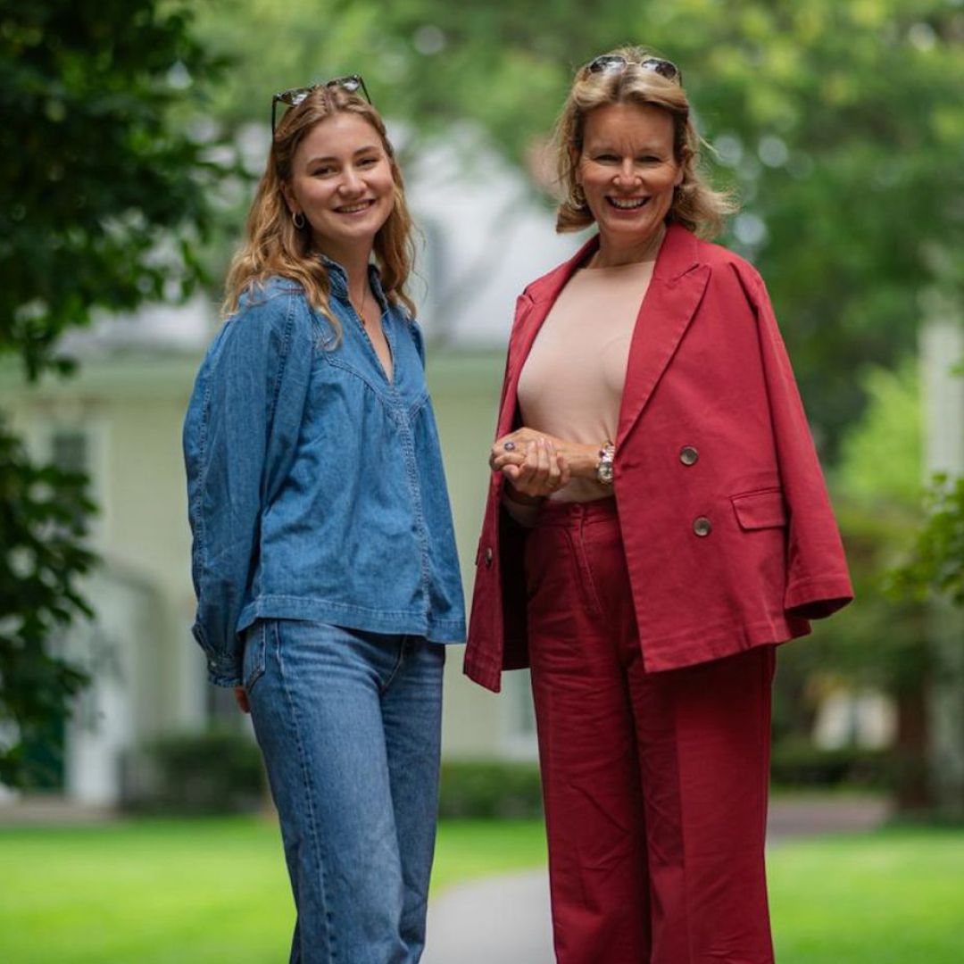 Princess Elisabeth in a denim shirt and jeans posing with Queen Mathilde