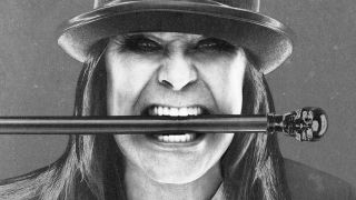 A black and white photo of Ozzy Osbourne holding a skull cane in his teeth