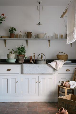 An example of mudroom ideas showing a mudroom with cream cabinets, a tiled floor and a sink area