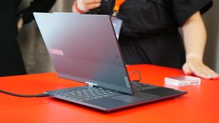 Lenovo Auto Twist AI PC in mid twist on a red tabletop