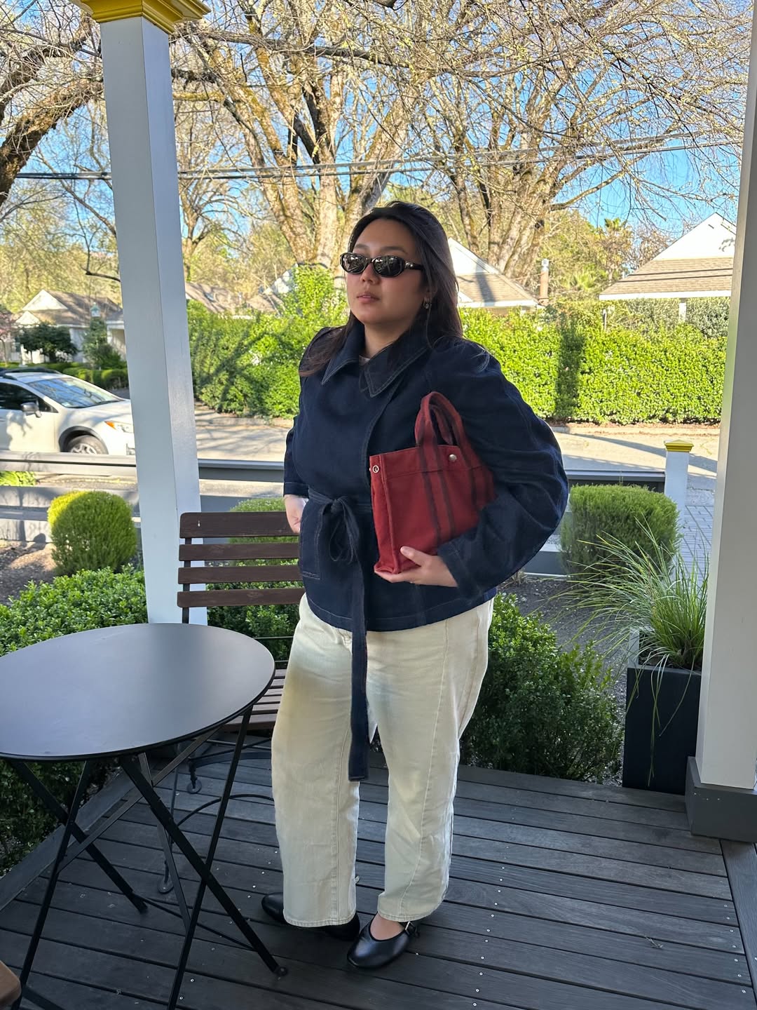 Influencer Marina Torres wearing a belted denim jacket, cream straight jeans and ballet flats.