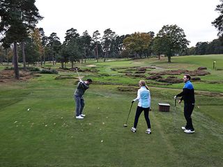 Golfers getting ready to play a par-3 hole on the tee at West Hill Golf Club