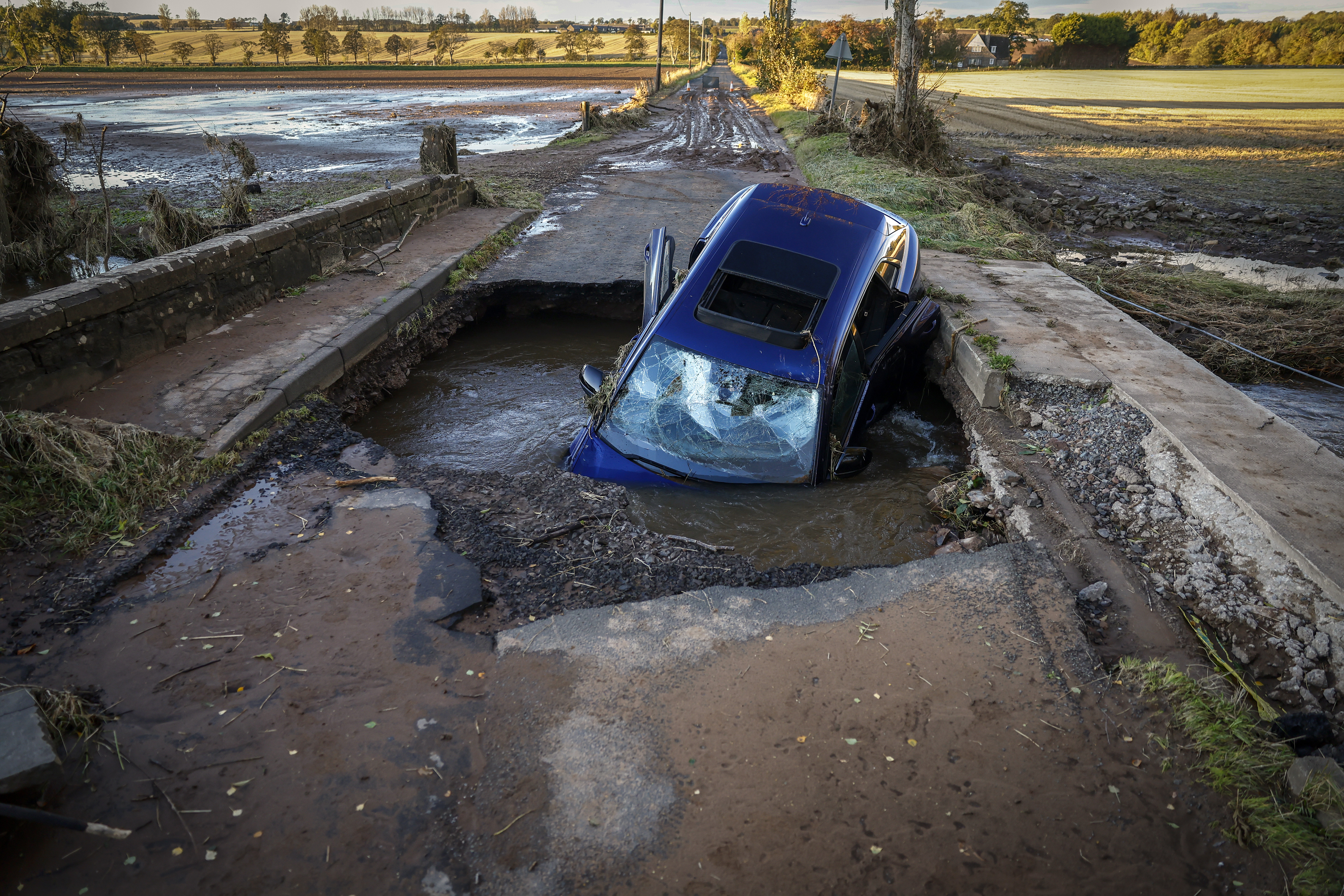 A car is almost swallowed by a sinkhole on a scottish road