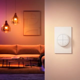 close up of a light switch with a sofa and lighting in the background