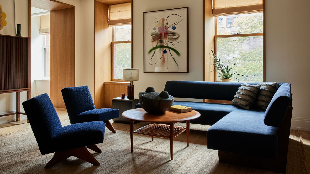 living room with wall art, navy blue sofa and armchairs, timber coffee table