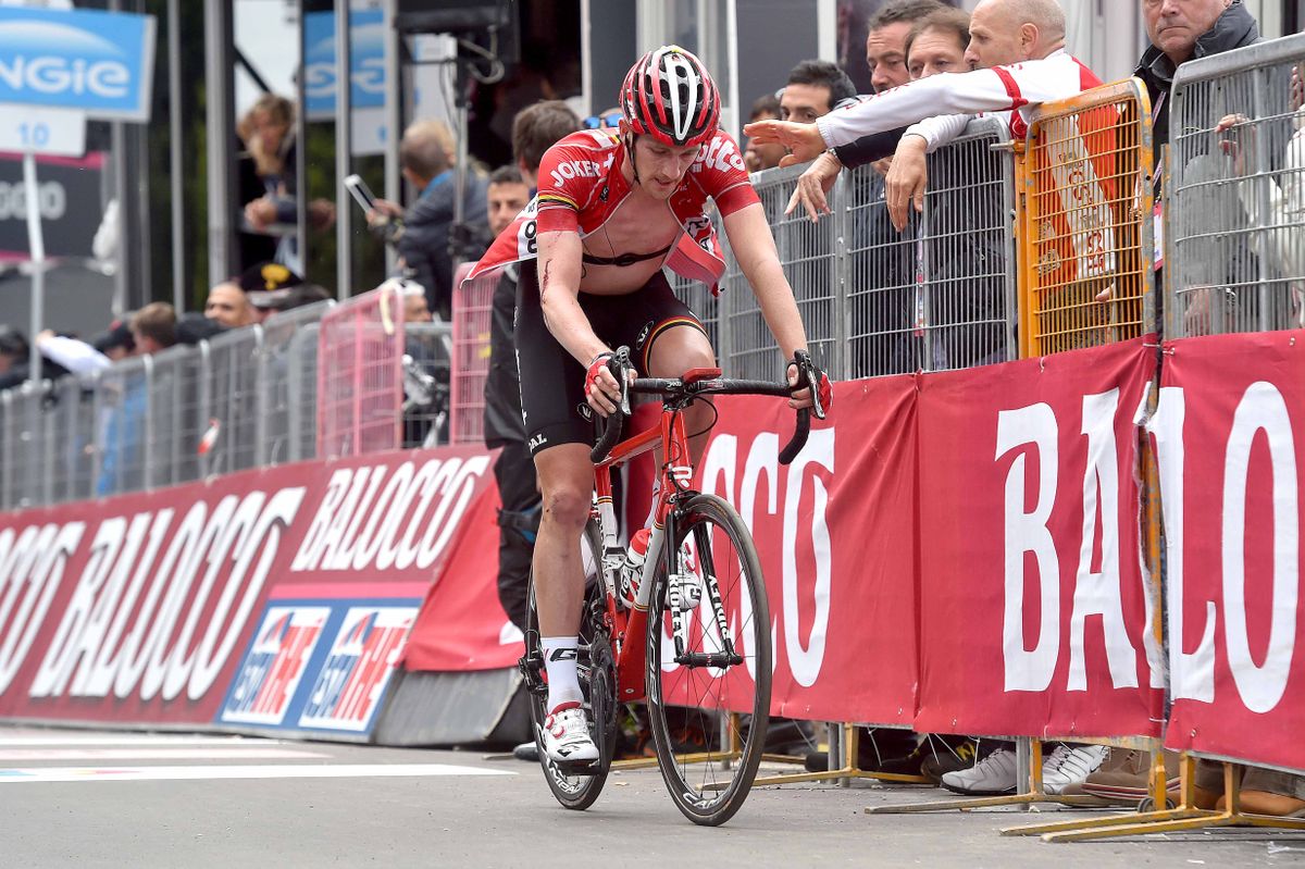 Blood drips from Jurgen Van den Broeck's elbow as he crosses the line