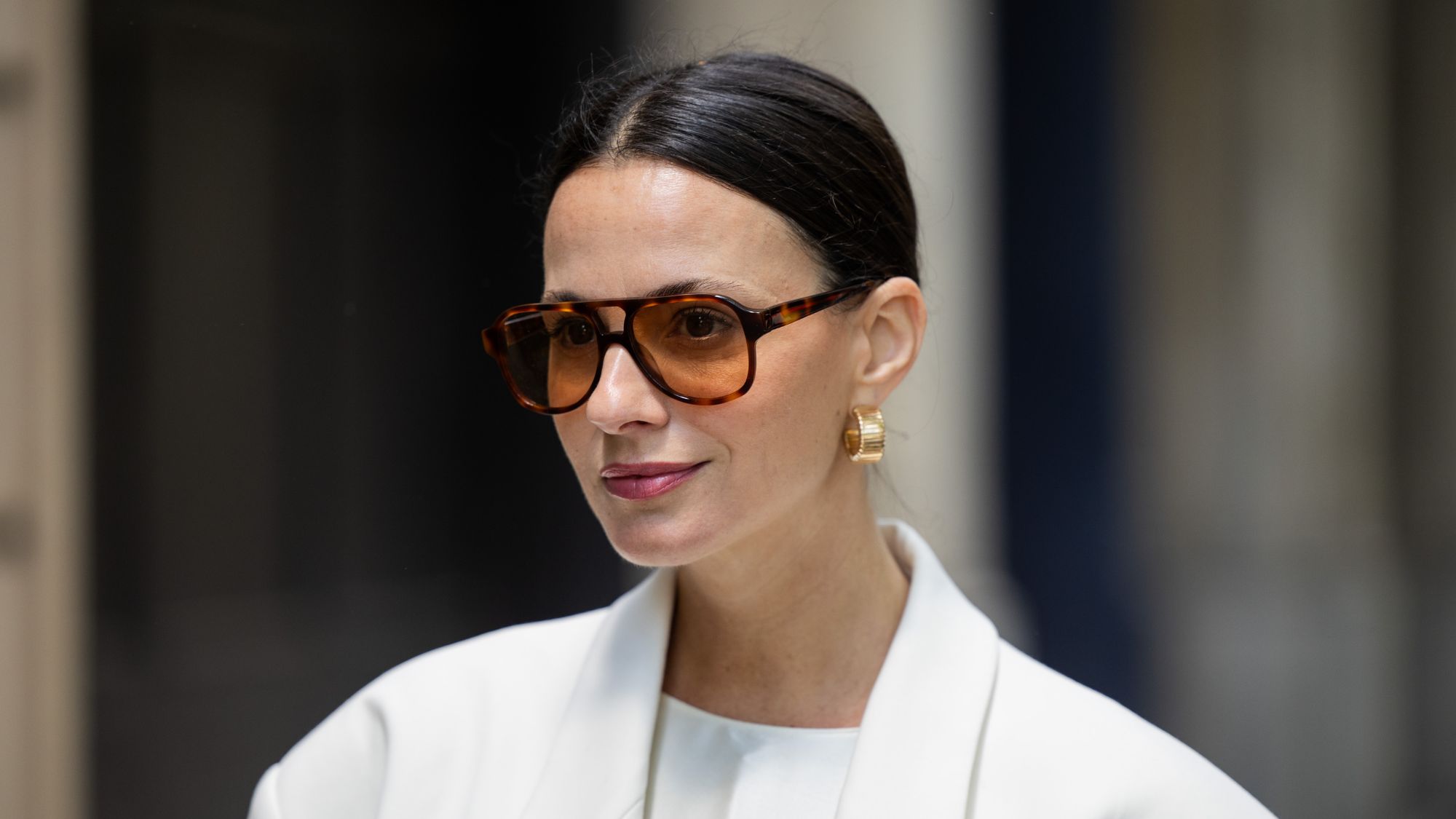 woman wearing aviator sunglasses with a light berry lipstick on