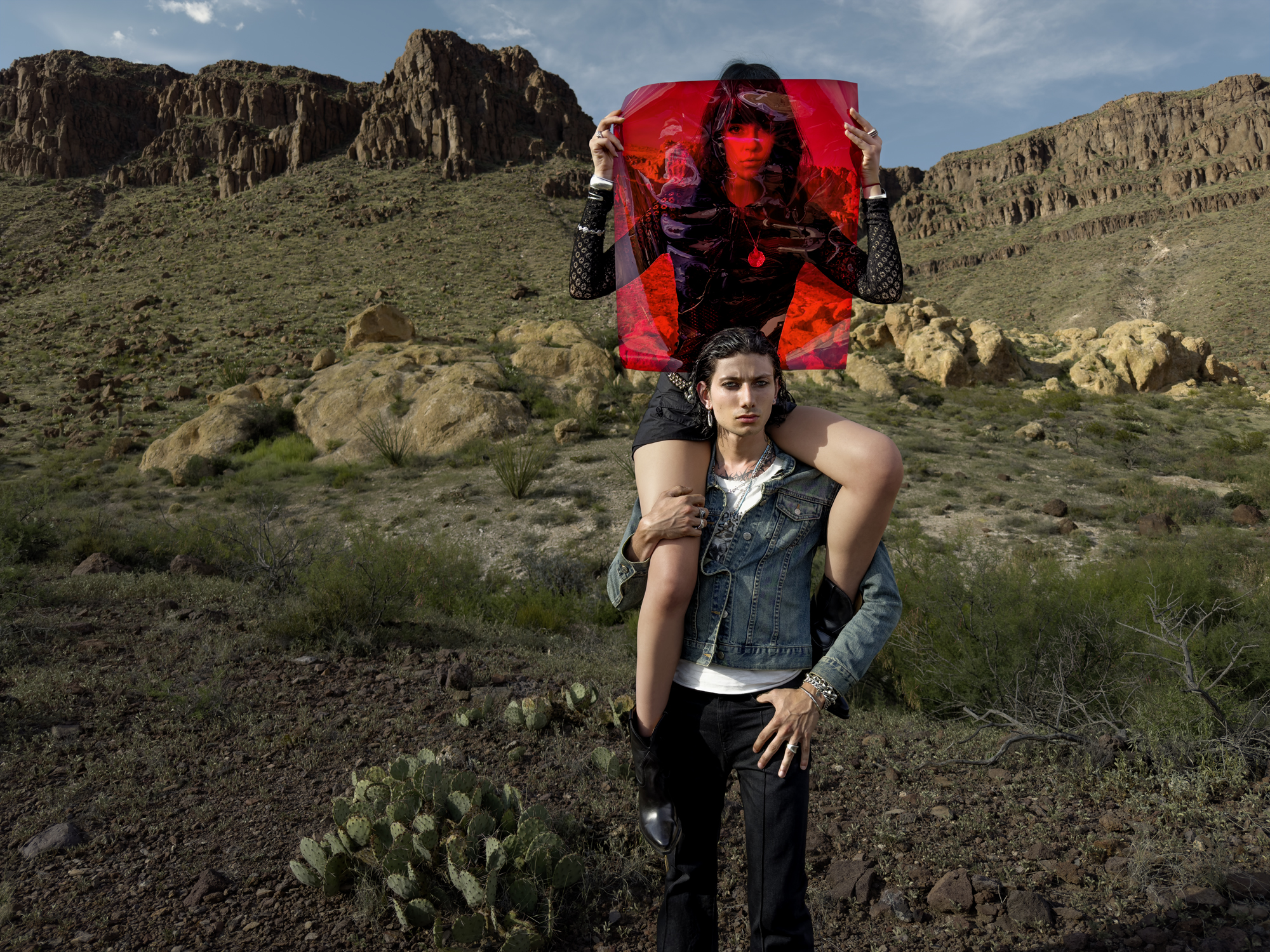 man and woman with red sheet in the desert