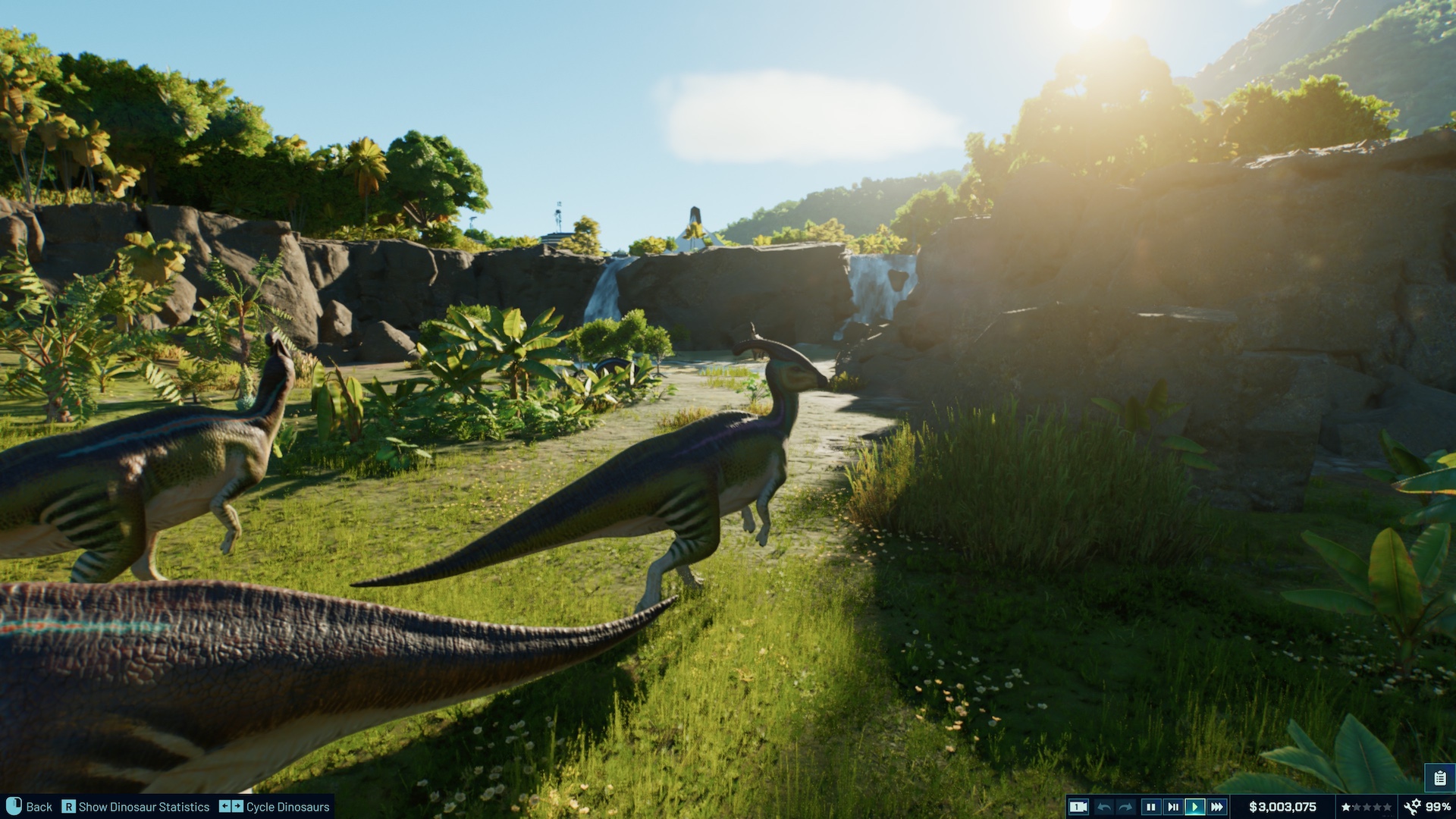 A herd of Parasaurolophus walking in front of a waterfall in Jurassic World Evolution 3