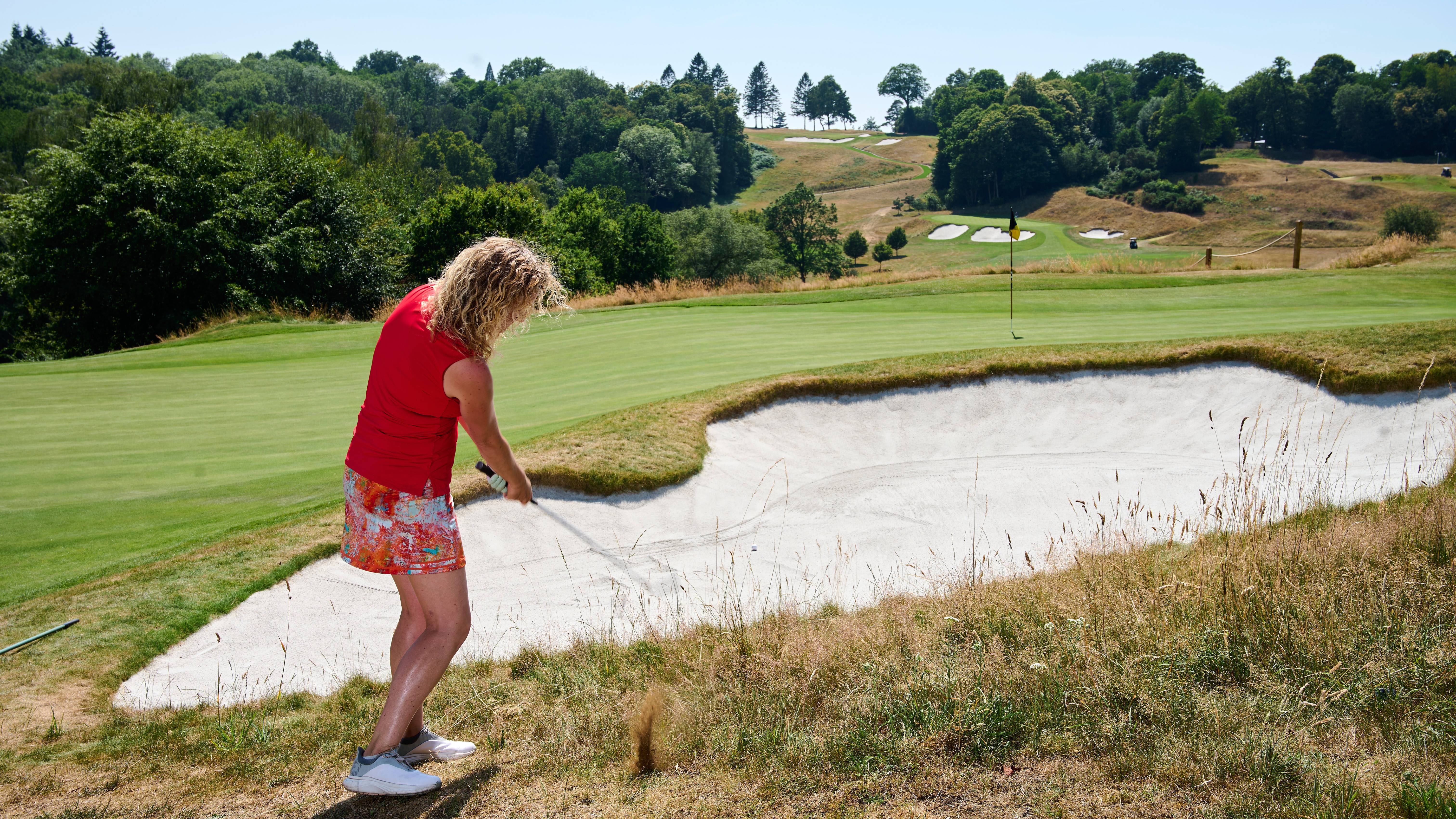 Katie Dawkins taking a practice swing outside a bunker
