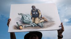 A demonstrator holds an anti-ICE sign while attending the "March on Washington: Defend the Vote" rally at the Lincoln Memorial.
