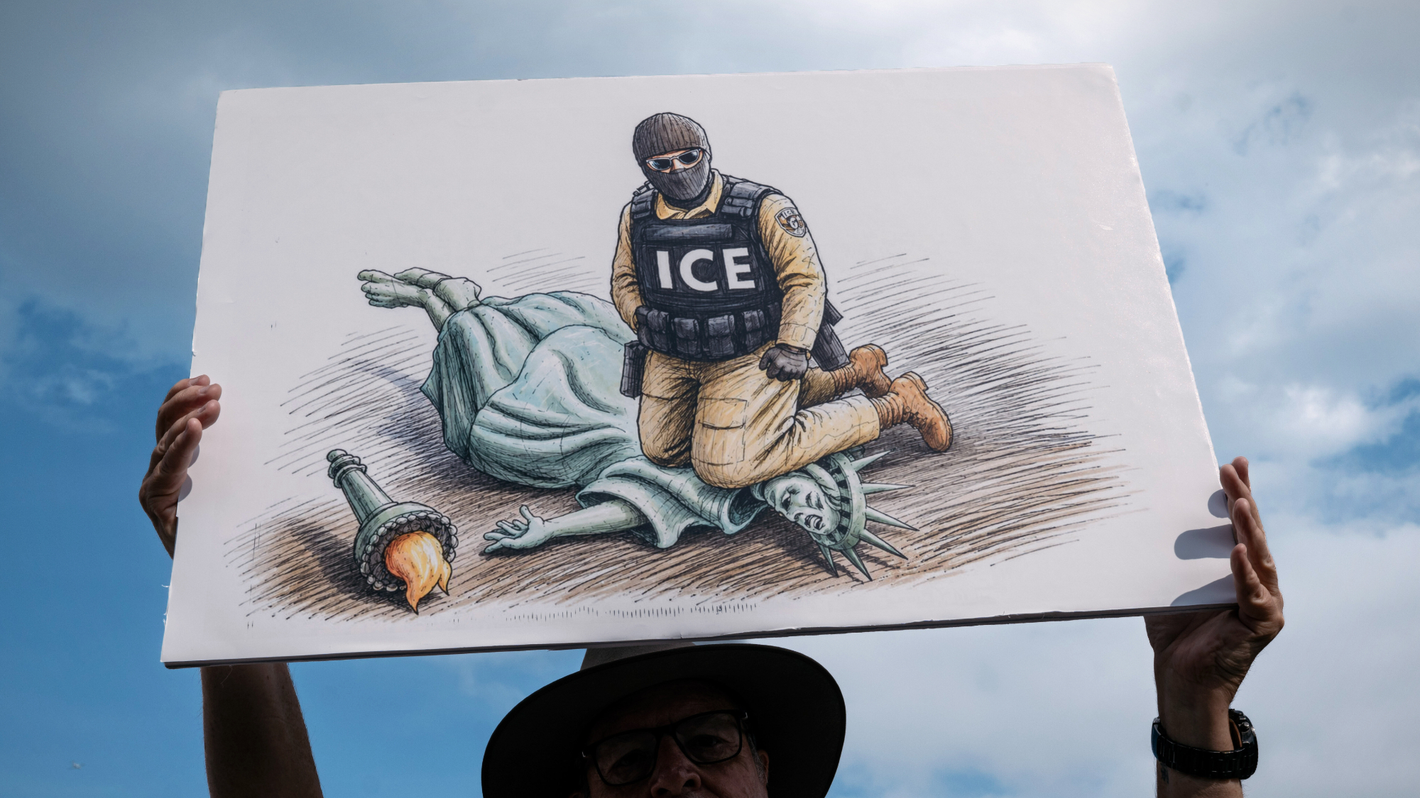 A demonstrator holds an anti-ICE sign while attending the "March on Washington: Defend the Vote" rally at the Lincoln Memorial.