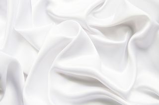 A close up of white bed sheets