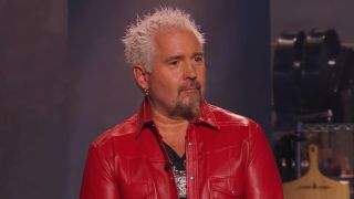 Guy Fieri in a red leather jacket talking on Tournament Of Champions.
