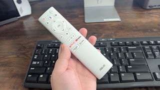 ASUS ZenScreen Smart TV MS27UC remote in hand.