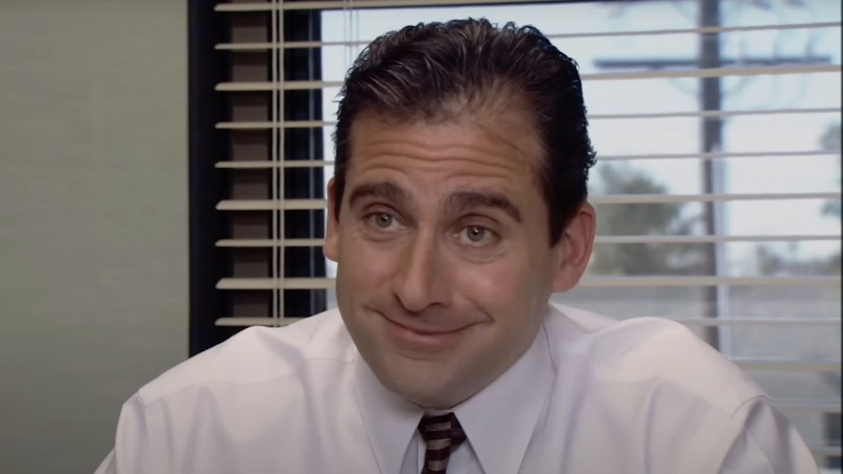 Steve Carell as Michael Scott smiling into the camera after making an inappropriate joke.