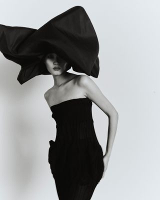 Woman in black dress and wrapped black hat
