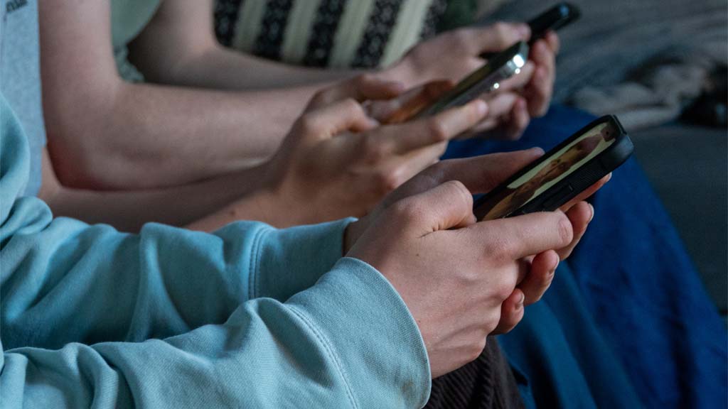 MORZINE, FRANCE - APRIL 11: Three teenage boys look at their smartphone screens in village of St Jean d'Aulps on April 11, 2026 near Morzine, France. (Photo by Matt Cardy/Getty Images)