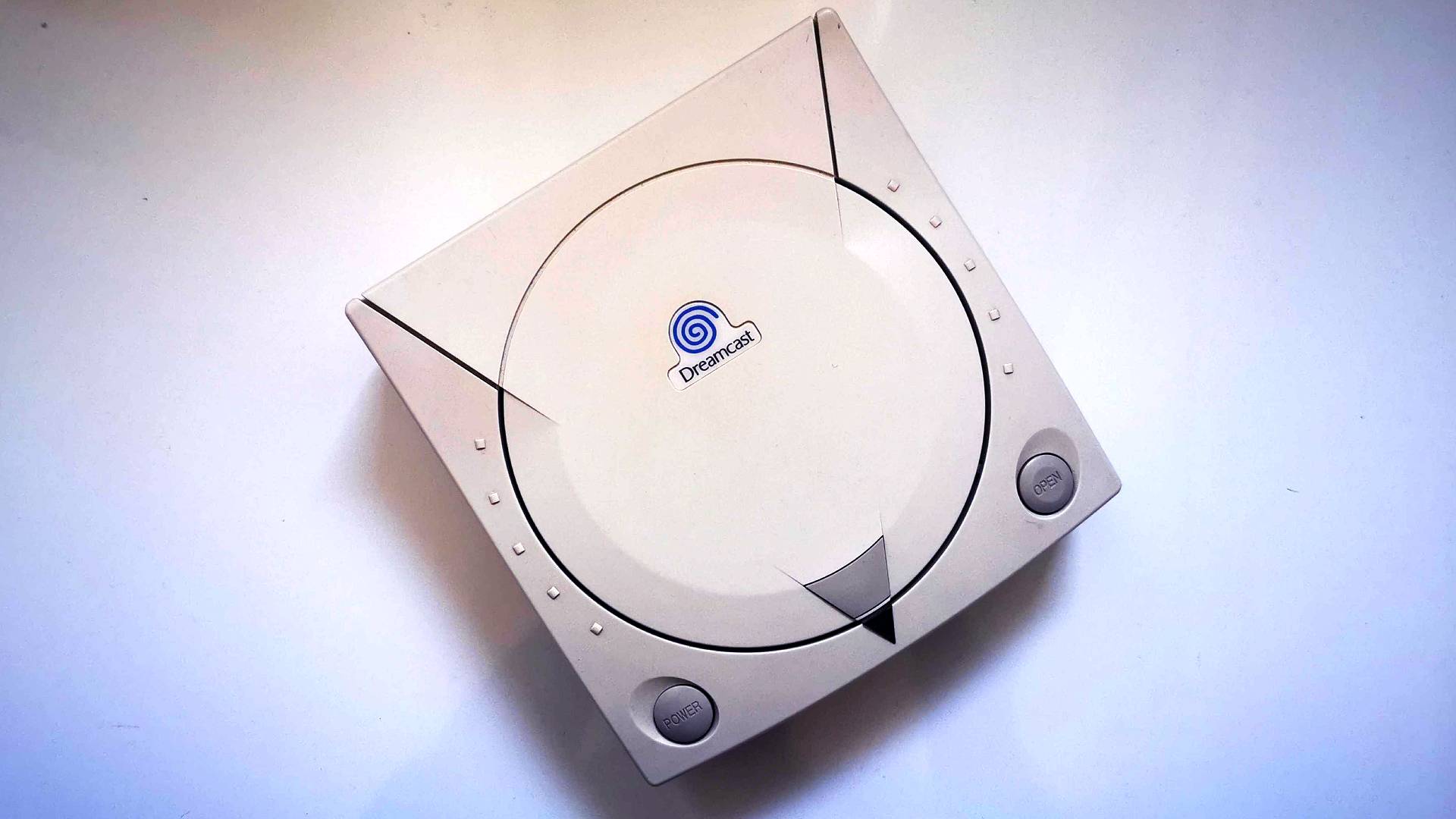 Top down view of Sega Dreamcast on white surface.
