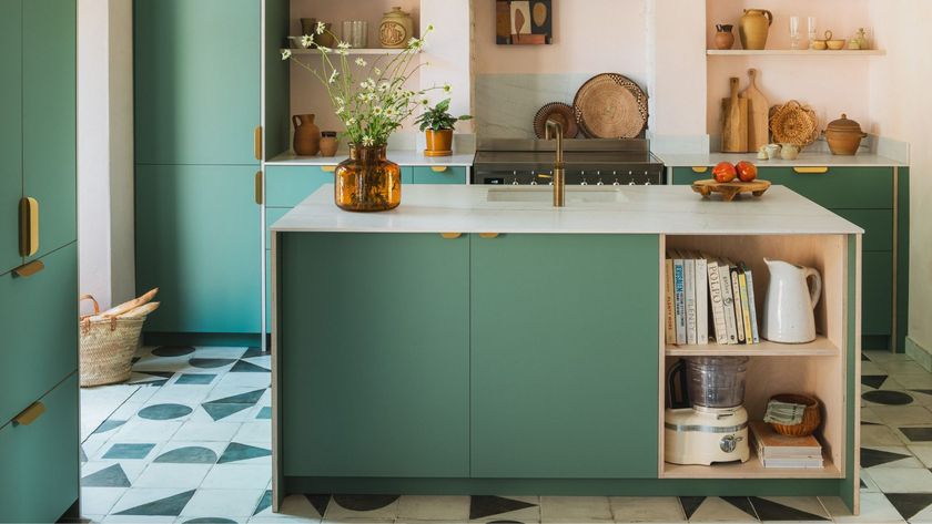 Fresh modern kitchen with matte green cabinetry, pale stone island, brass accents, open shelving, and patterned tile flooring for a warm, contemporary feel.