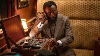 Babs Olusanmokun stationed at a radio in a train car in The Ministry of Ungentlemanly Warfare.